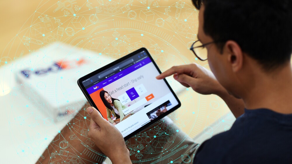 Person using a tablet displaying the FedEx website, surrounded by abstract digital graphics. There is a FedEx box in the background. 