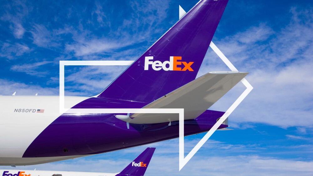 Two FedEx purple-tail aircraft lined up on a clear day with FedEx arrow overlay in white