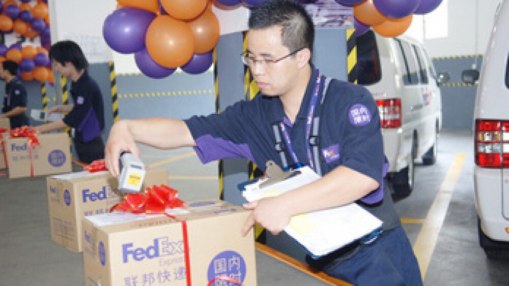 a-fedex-courier-scanning-a-commemorative-package-for-its-newly-launched-domestic-time-definite-service.jpg