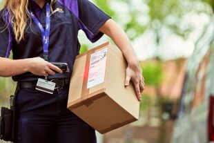 FedEx courier carrying brown package