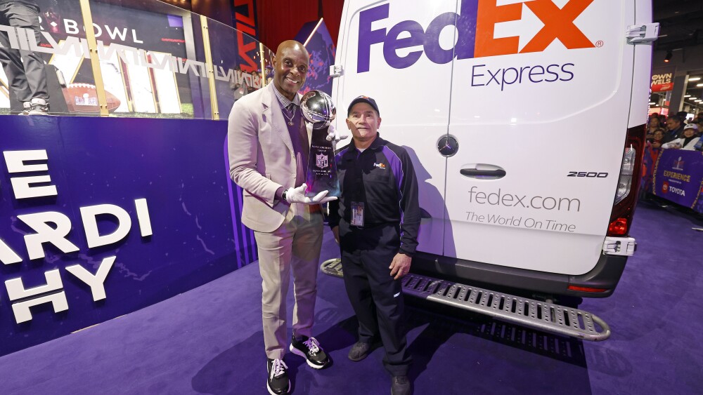 Jerry Rice and FedEx Express courier Bob Fini following the delivery of the Vince Lombardi Trophy.