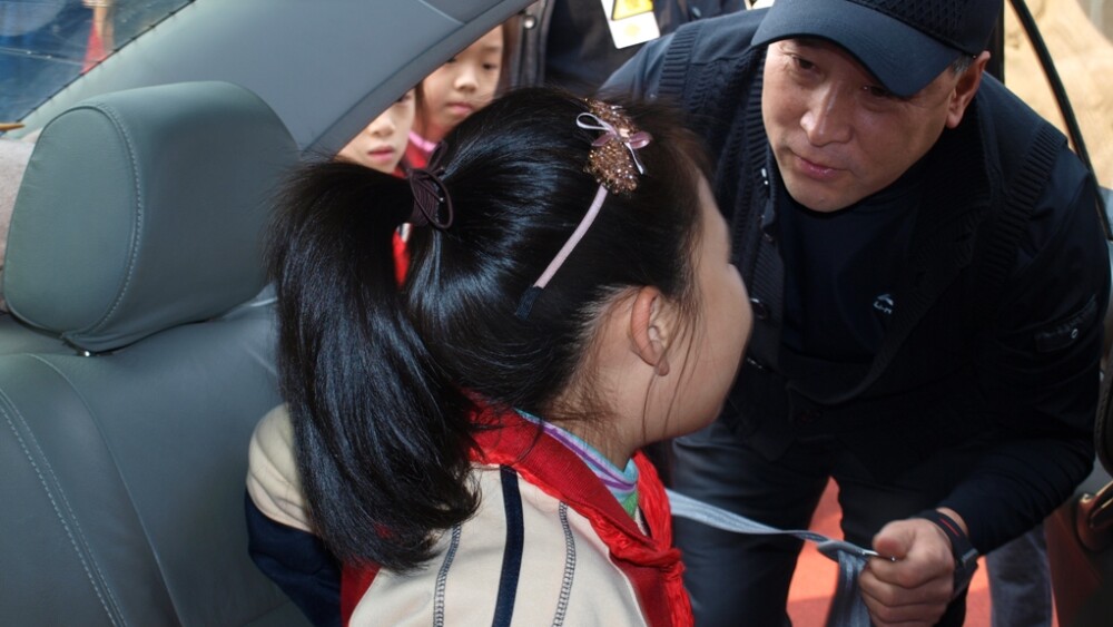 li-yongbo-head-coach-of-china-badminton-team-helps-a-student-fasten-the-seatbelt.jpg