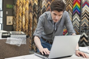 A man working at a frame store